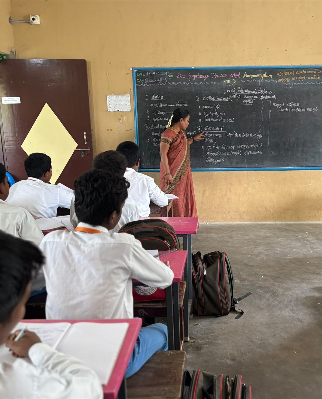 A teacher at the blackboard with a class in progress
