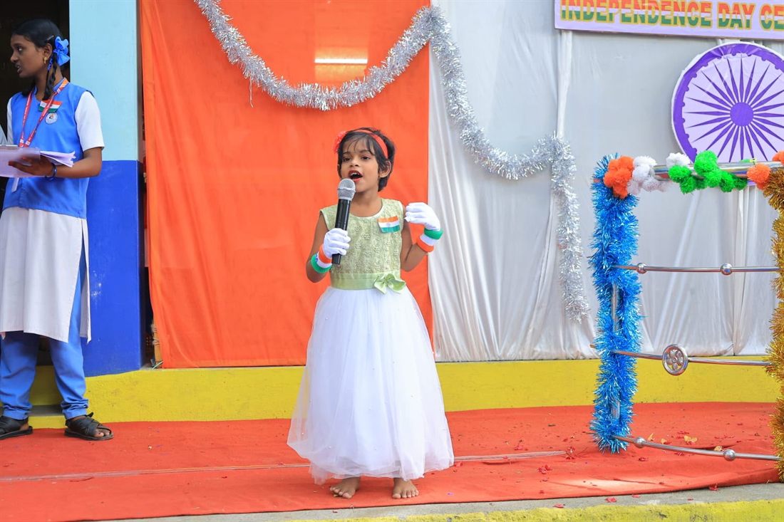 A young student singing on the Annual Day stage