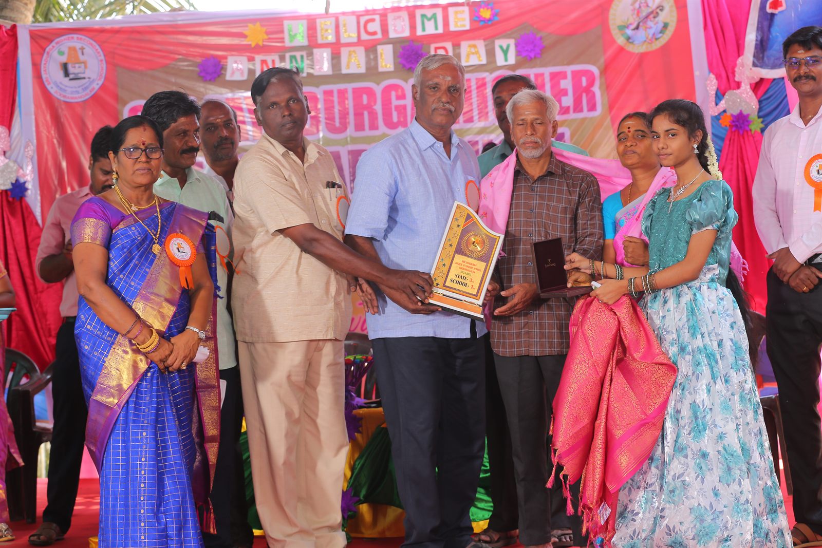 Annual Day — a student receiving the state rank award on stage with her parents