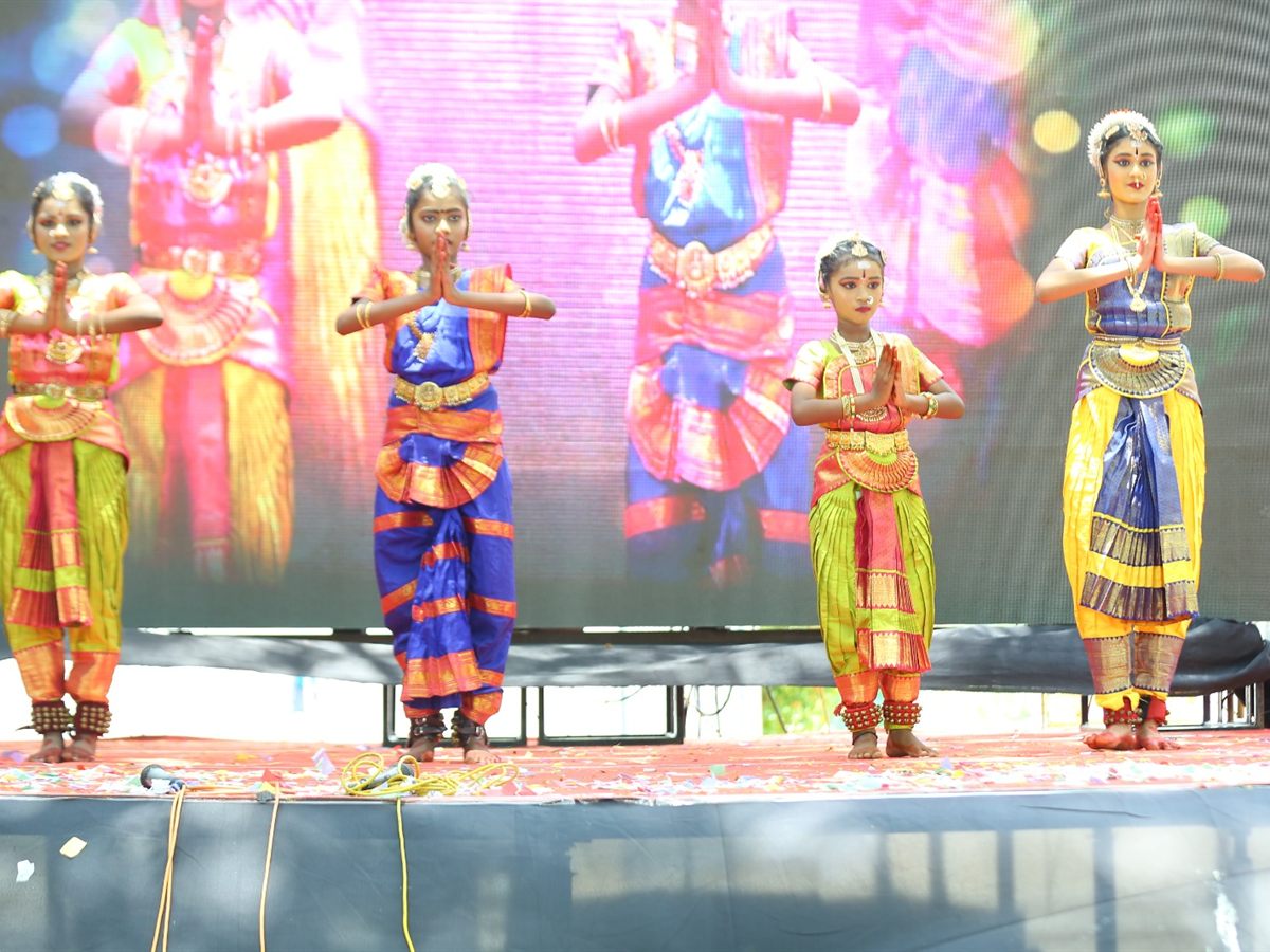 Four students in Bharatanatyam costume opening their dance with folded hands