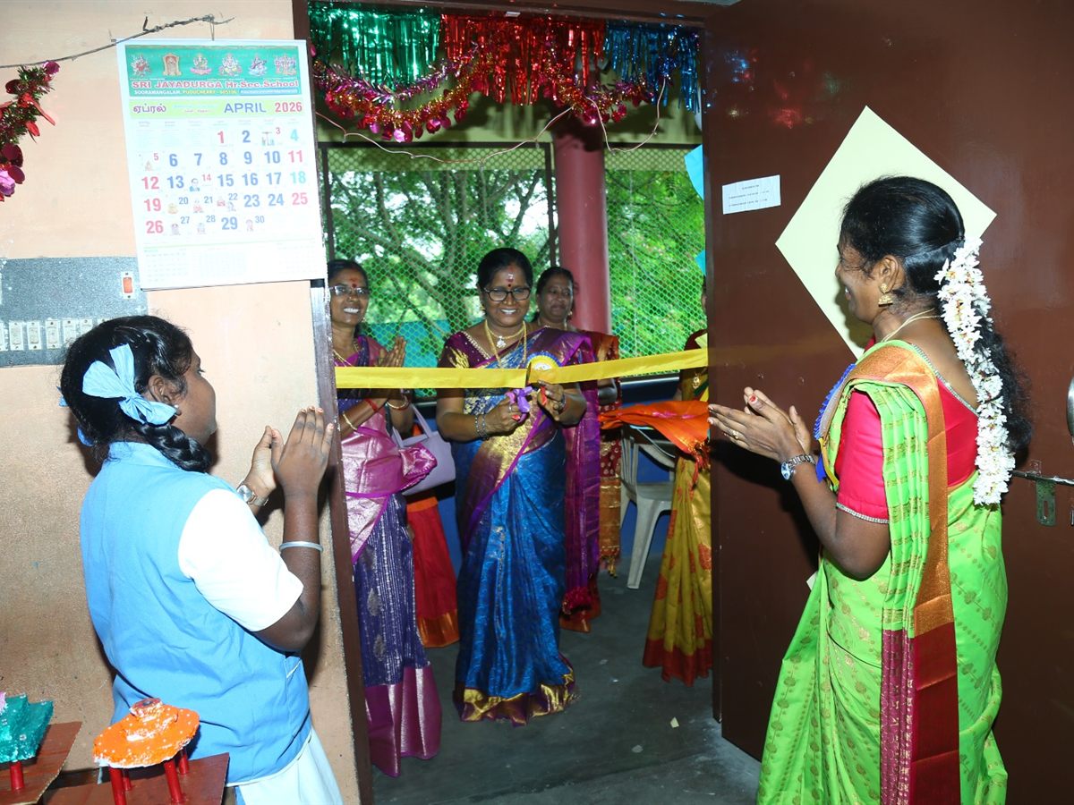 Teachers applauding as the ribbon is cut to open a room at the school