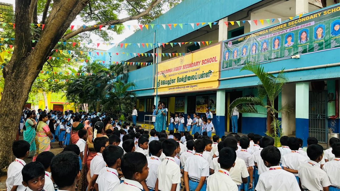 The school frontage on a festival morning, flags strung between the trees