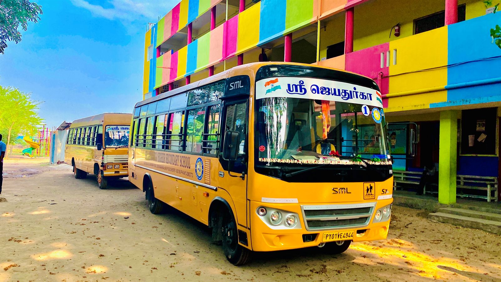 The school buses parked beside the building, with the ground and play area behind
